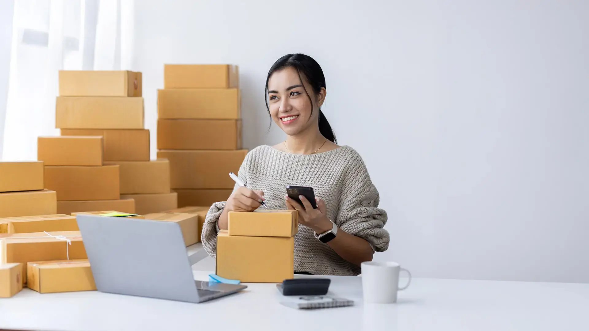 Mujer emprendedora gestionando pedidos en su negocio, consultando los servicios de defensa de deudas para pymes de Grupo Defensa.